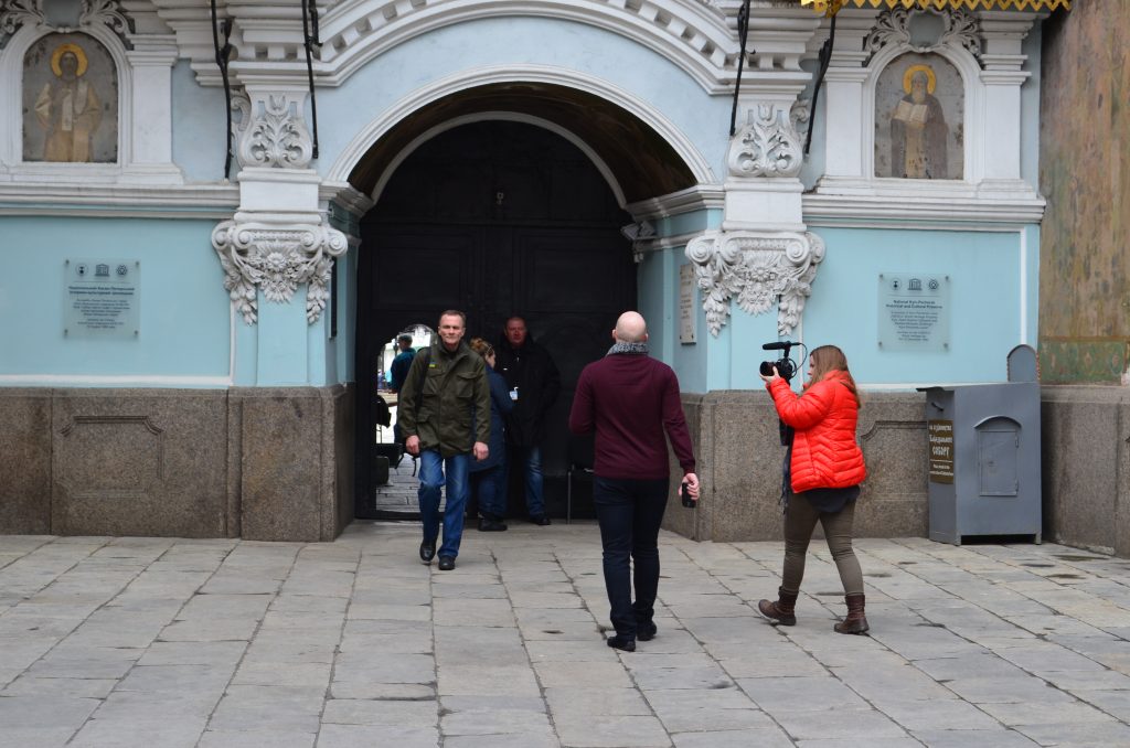 A group of people walking in front of a building

Description automatically generated