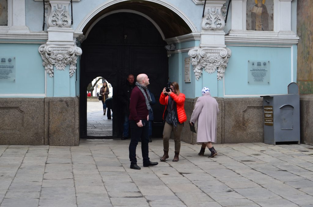 A statue of two people standing in front of a building

Description automatically generated